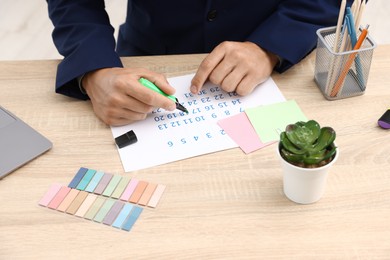 Photo of Business planning. Man with calendar at wooden table in office, closeup