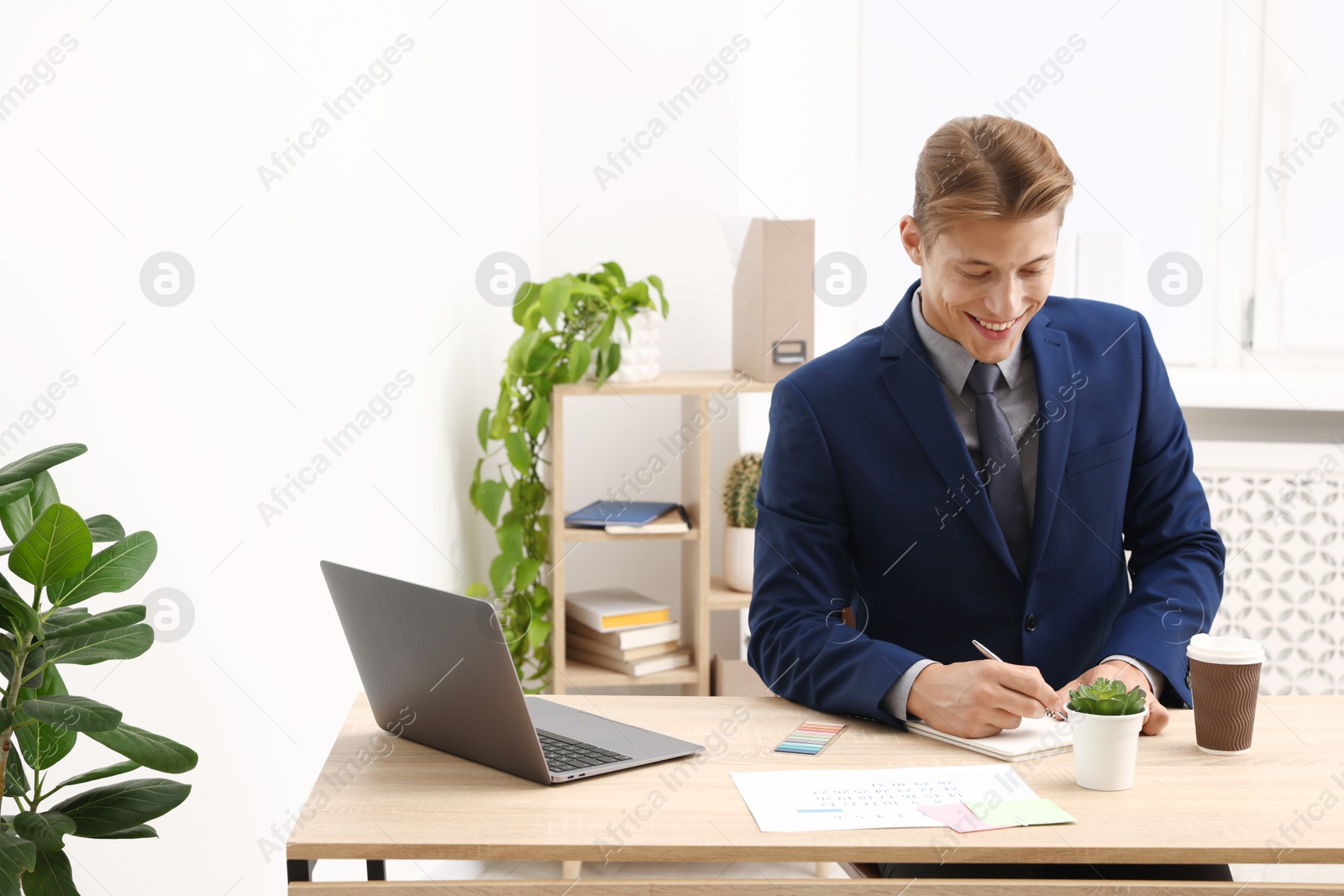 Man using business planner at wooden table in office Photo of Man using business planner at wooden table in office