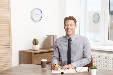 Photo of Business planning. Man with calendar at wooden table in office