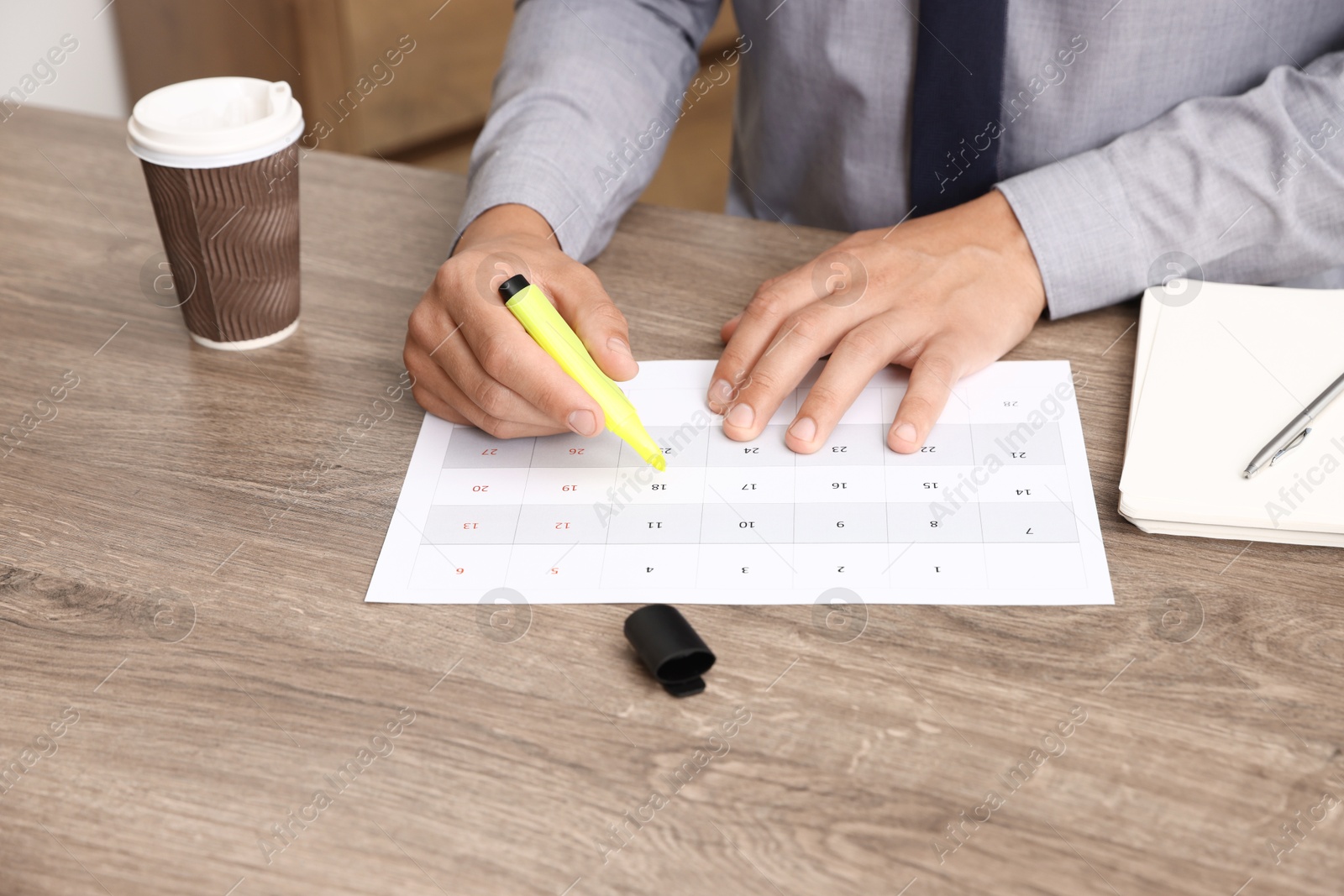 Business planning. Man with calendar at wooden table in office, closeup Photo of Business planning. Man with calendar at wooden table in office, closeup