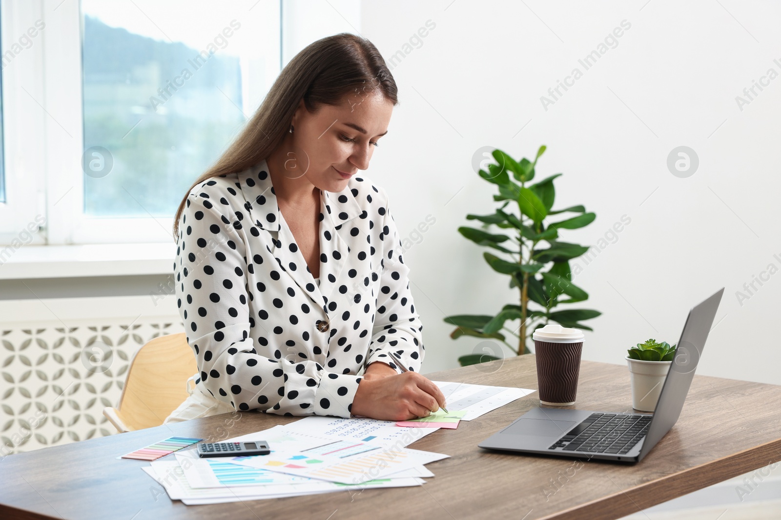 Business planning. Woman with calendar and other documents at wooden table in office Photo of Business planning. Woman with calendar and other documents at wooden table in office