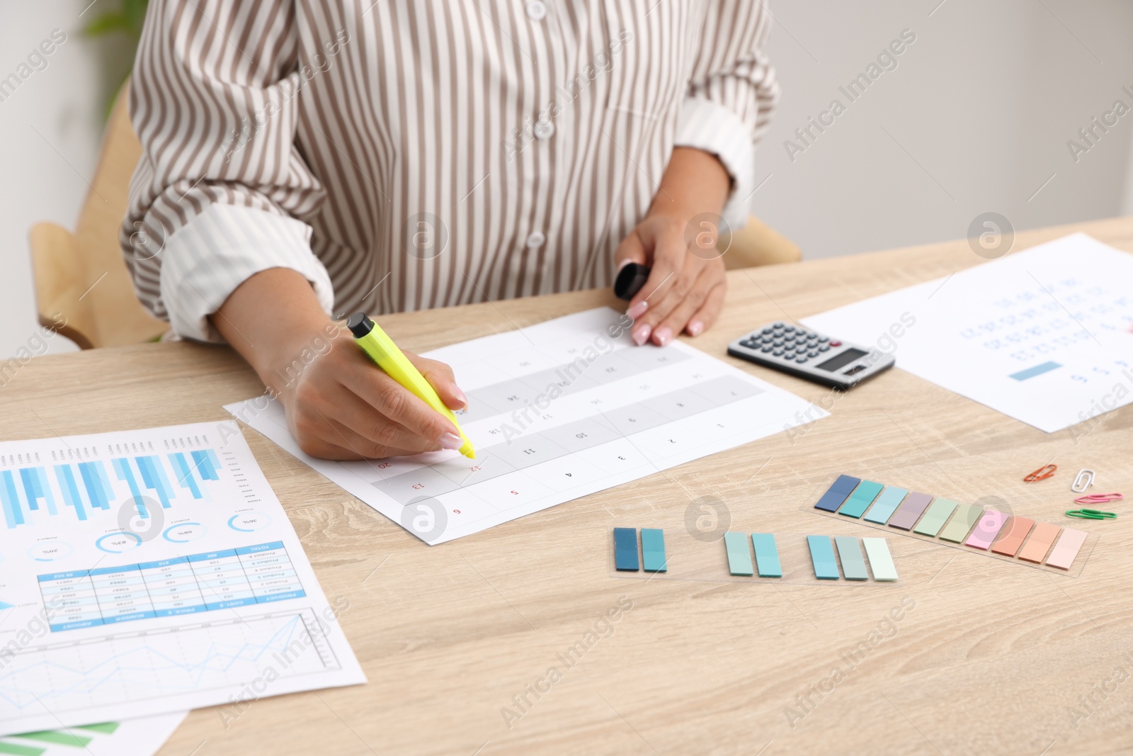 Business planning. Woman with calendar at wooden table in office, closeup Photo of Business planning. Woman with calendar at wooden table in office, closeup