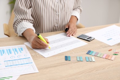 Photo of Business planning. Woman with calendar at wooden table in office, closeup