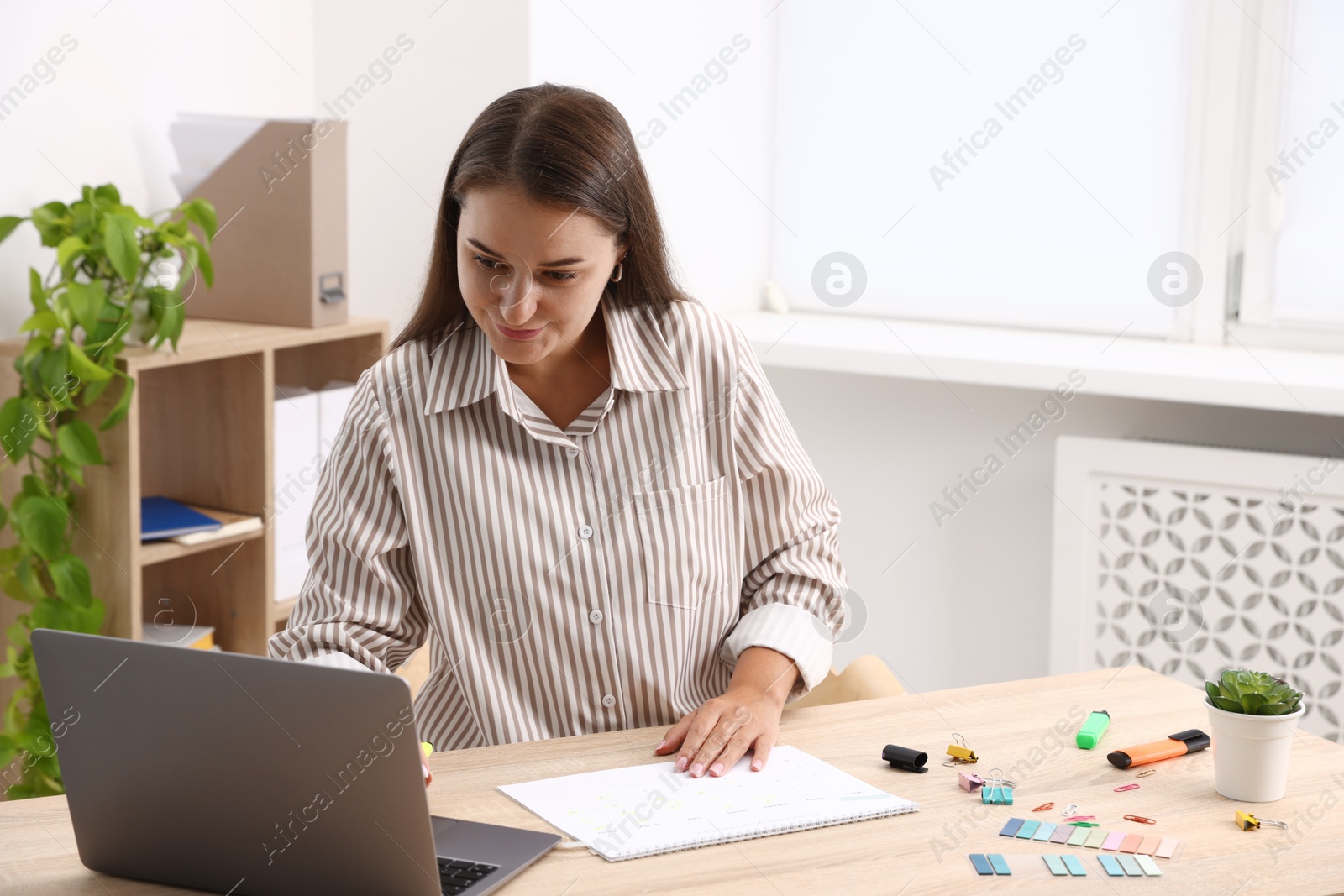 Photo of Business planning. Woman with calendar at wooden table in office