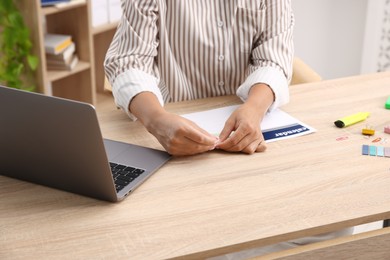 Photo of Business planning. Woman using calendar at wooden table in office, closeup