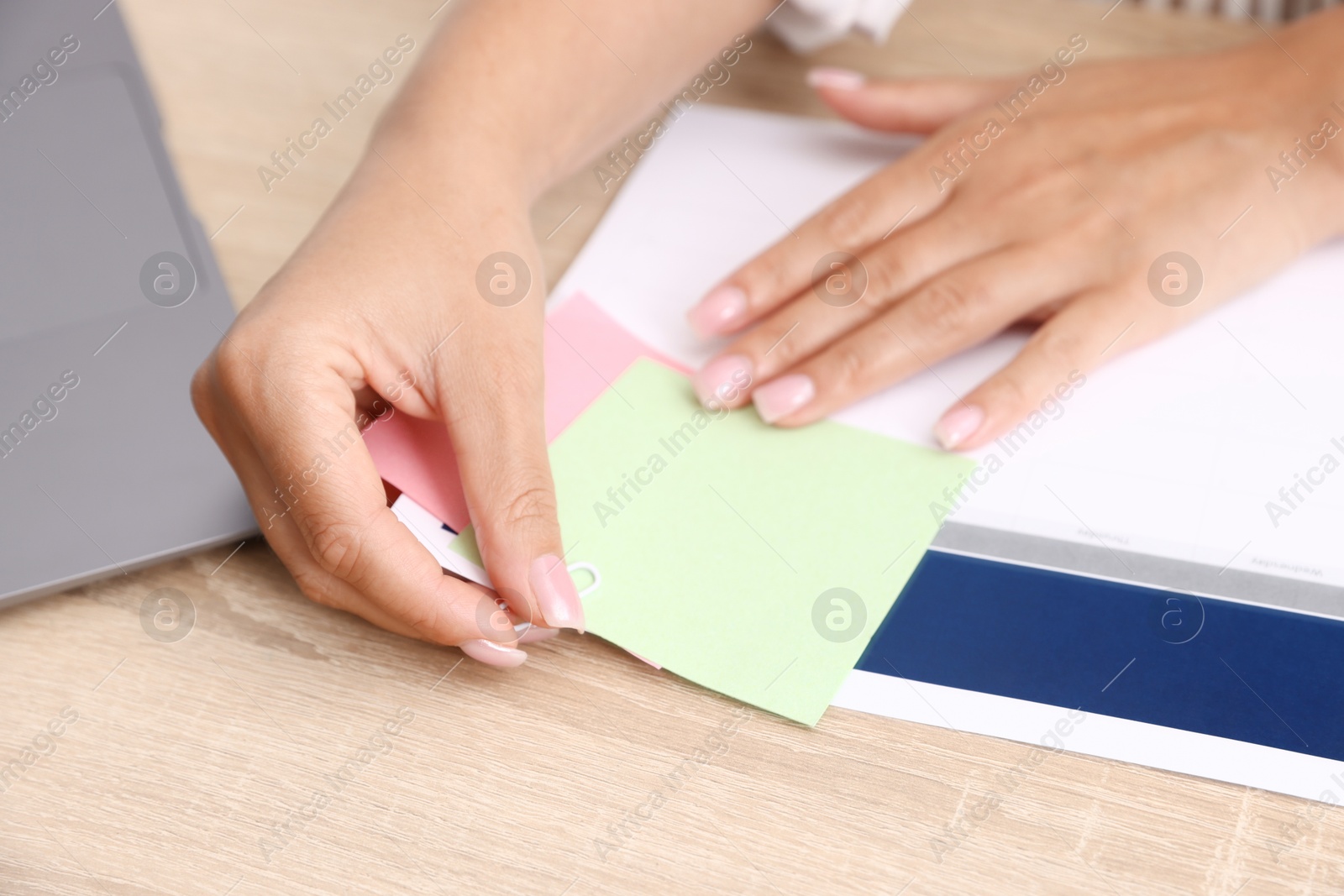 Business planning. Woman using calendar at wooden table in office, closeup Photo of Business planning. Woman using calendar at wooden table in office, closeup