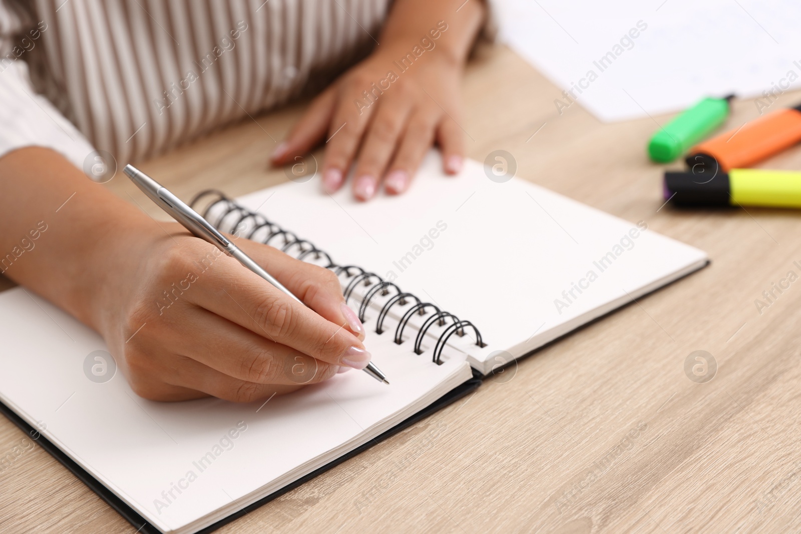 Woman using business planner at wooden table in office, closeup Photo of Woman using business planner at wooden table in office, closeup