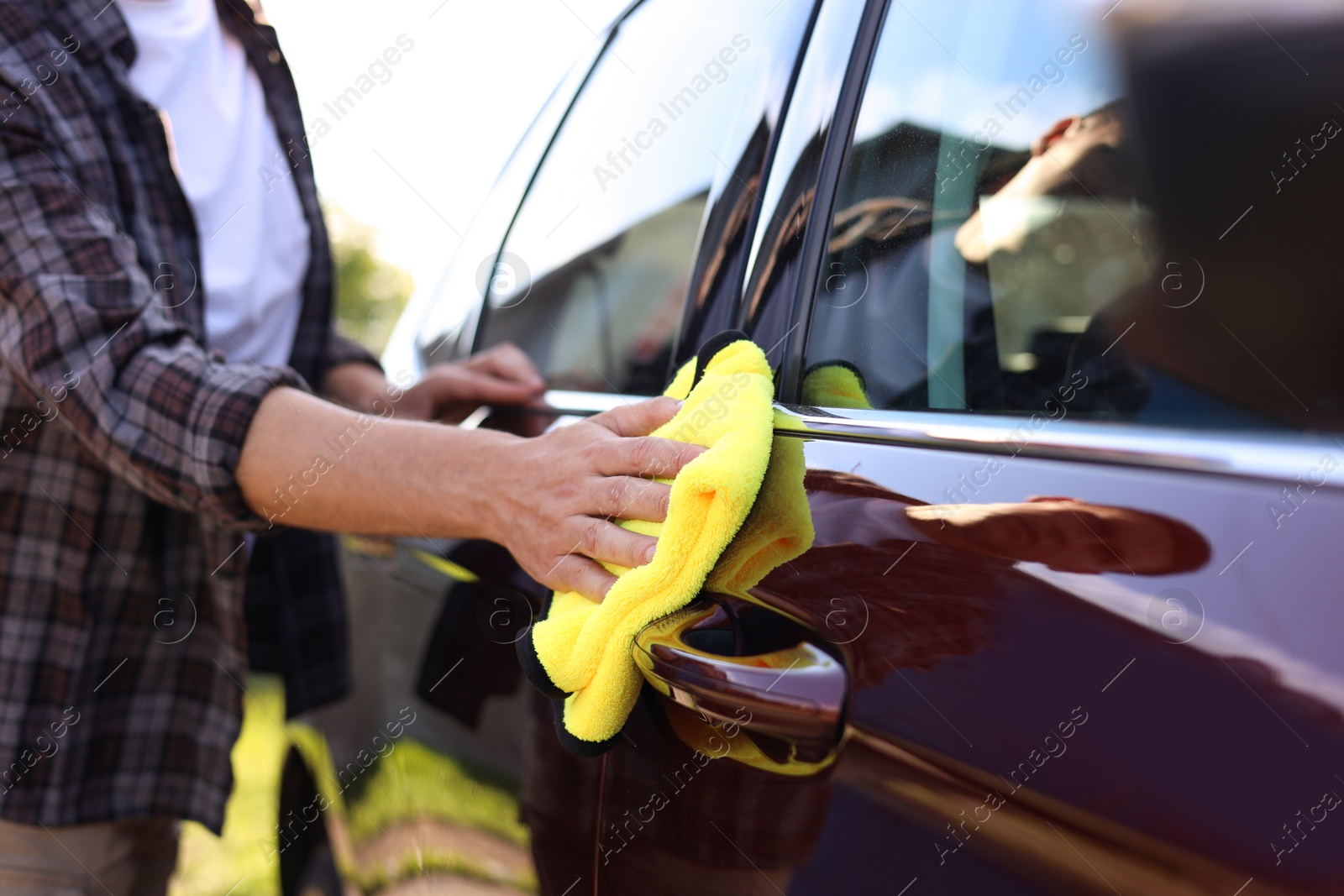 Man wiping car with yellow microfiber rag outdoors, closeup Photo of Man wiping car with yellow microfiber rag outdoors, closeup