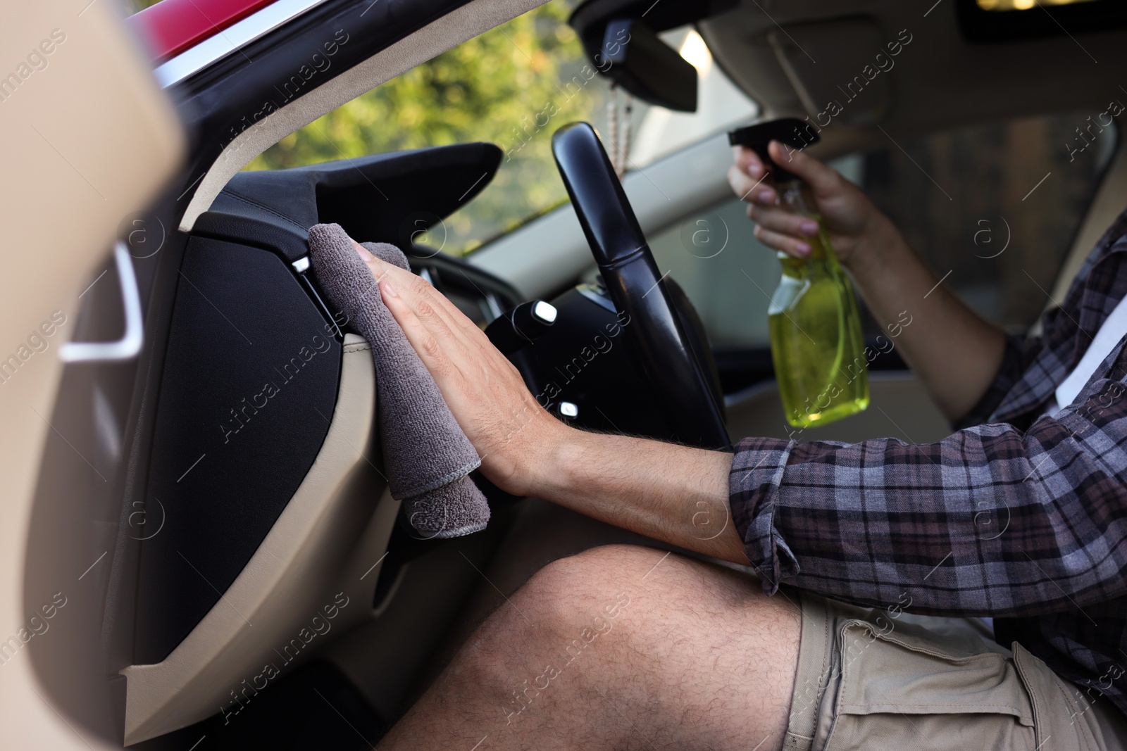 Man wiping car interior with grey microfiber rag in salon, closeup Photo of Man wiping car interior with grey microfiber rag in salon, closeup