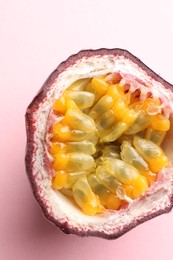Photo of Half of fresh passion fruit on pink background, closeup