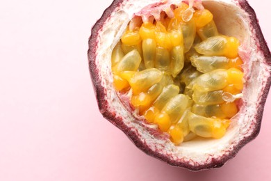 Photo of Half of fresh passion fruit on pink background, closeup. Space for text