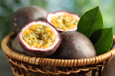 Photo of Fresh passion fruits in wicker basket on table outdoors, closeup