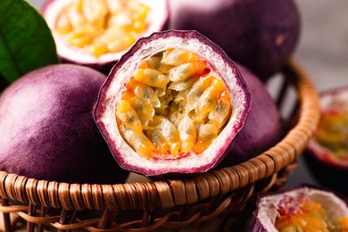 Photo of Fresh passion fruits in wicker basket on table, closeup
