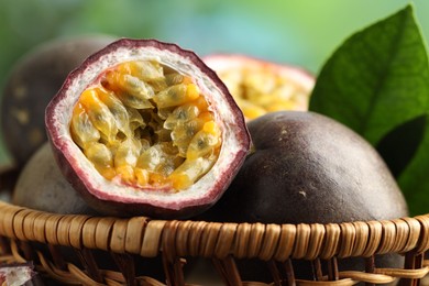 Photo of Fresh passion fruits in wicker basket outdoors, closeup
