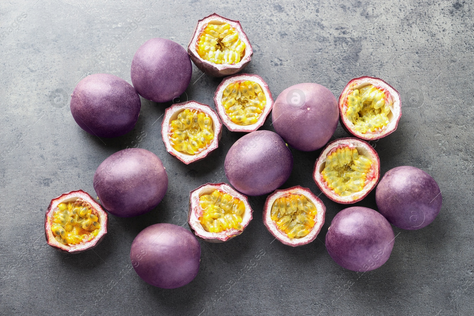 Photo of Fresh passion fruits on grey table, flat lay