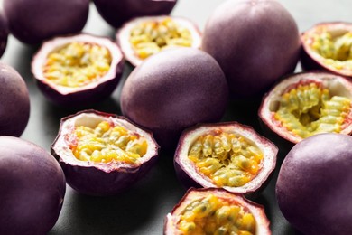 Photo of Fresh passion fruits on grey table, closeup