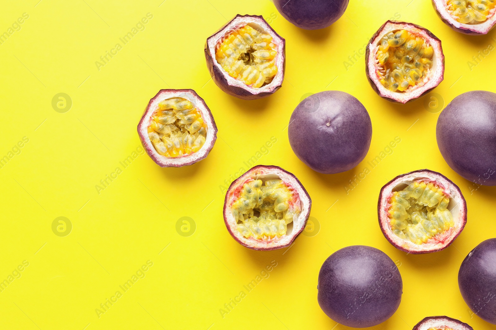 Photo of Fresh passion fruits on yellow background, flat lay. Space for text