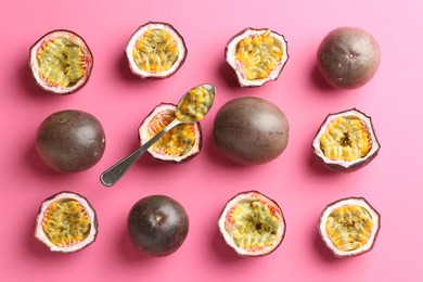 Photo of Fresh passion fruits and spoon on pink background, flat lay