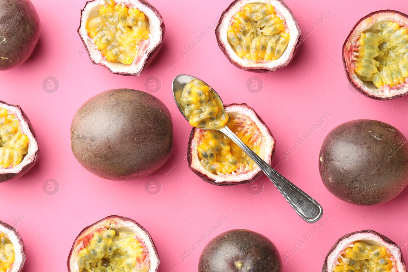 Fresh passion fruits and spoon on pink background, flat lay Photo of Fresh passion fruits and spoon on pink background, flat lay