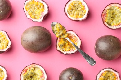 Photo of Fresh passion fruits and spoon on pink background, flat lay
