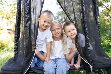 Photo of Happy children posing on black trampoline outdoors