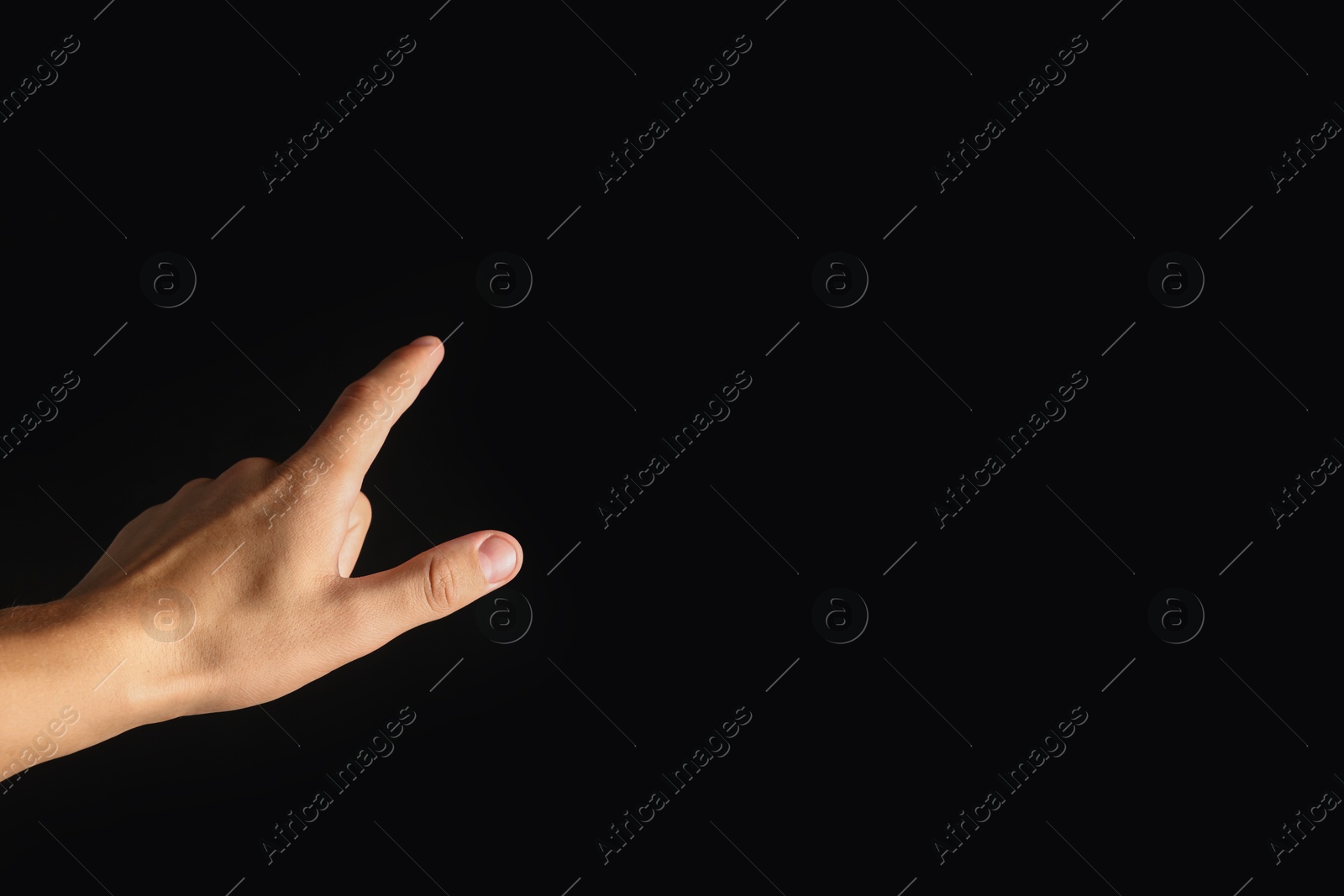 Photo of Man touching something on black background, closeup. Space for text