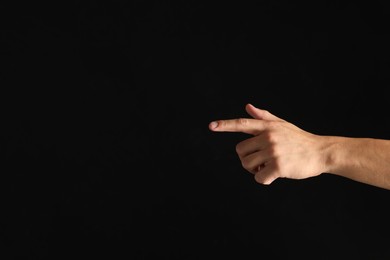 Photo of Man touching something on black background, closeup. Space for text