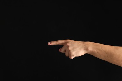 Photo of Man touching something on black background, closeup. Space for text