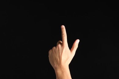 Photo of Man touching something on black background, closeup
