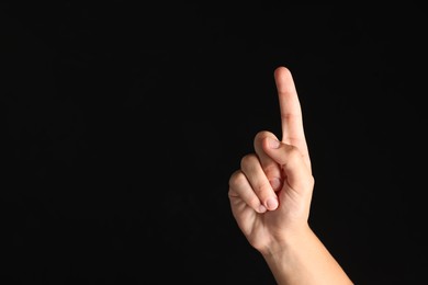 Photo of Man touching something on black background, closeup. Space for text