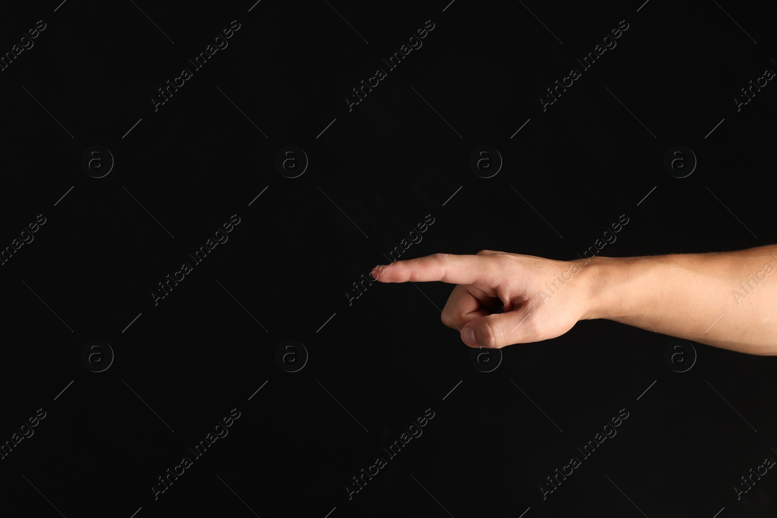 Photo of Man touching something on black background, closeup. Space for text