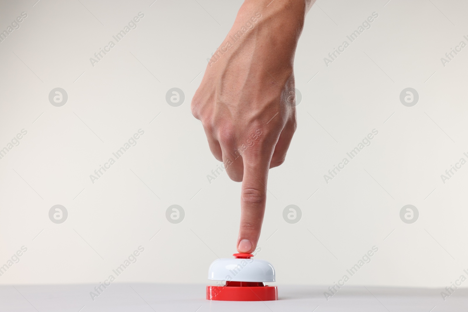 Man pressing red button on white background, closeup Photo of Man pressing red button on white background, closeup