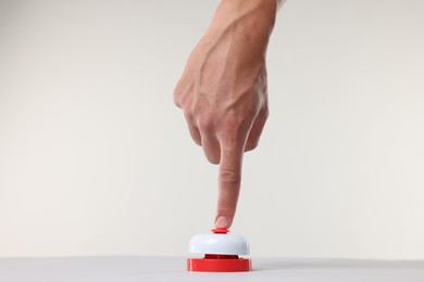 Photo of Man pressing red button on white background, closeup