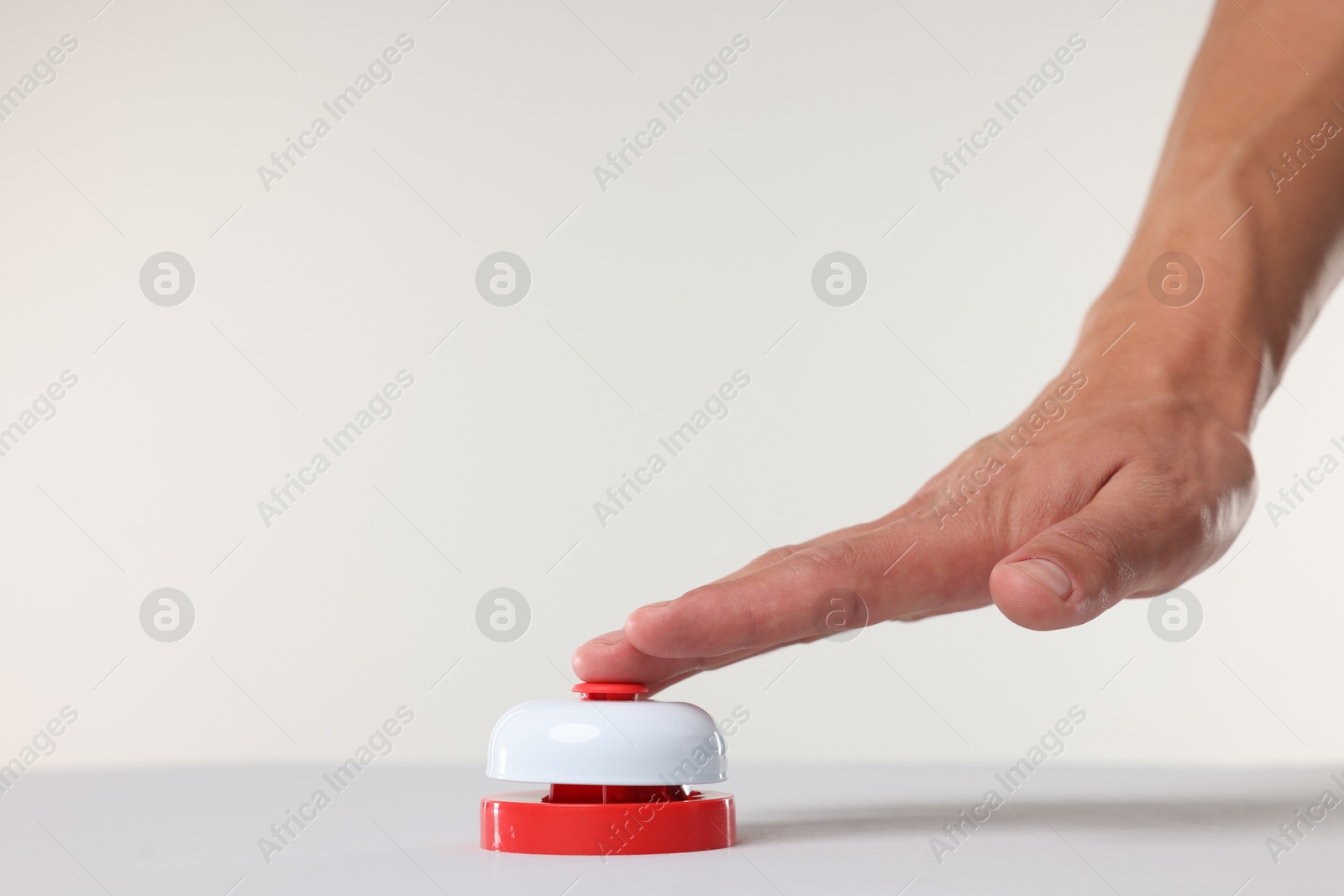 Man pressing red button on white background, closeup Photo of Man pressing red button on white background, closeup