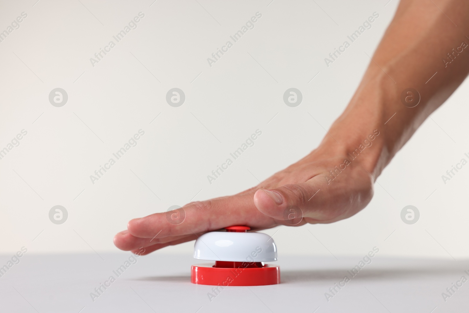 Man pressing red button on white background, closeup Photo of Man pressing red button on white background, closeup