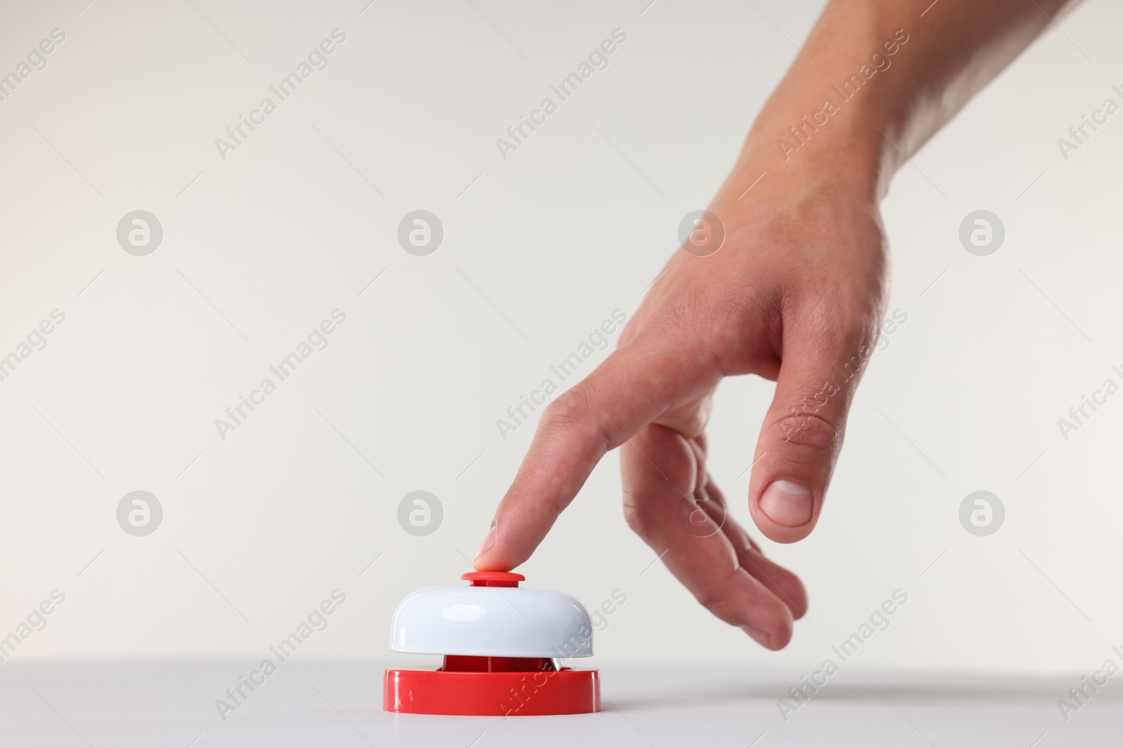 Man pressing red button on white background, closeup Photo of Man pressing red button on white background, closeup