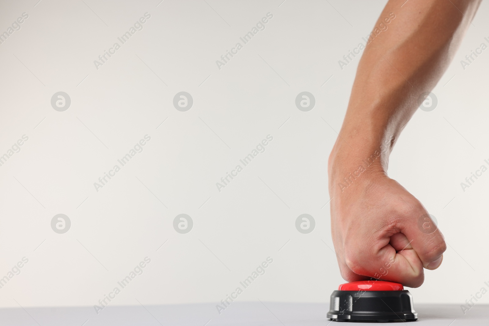 Man pressing red button on white background, closeup. Space for text Photo of Man pressing red button on white background, closeup. Space for text