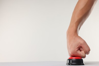 Photo of Man pressing red button on white background, closeup. Space for text