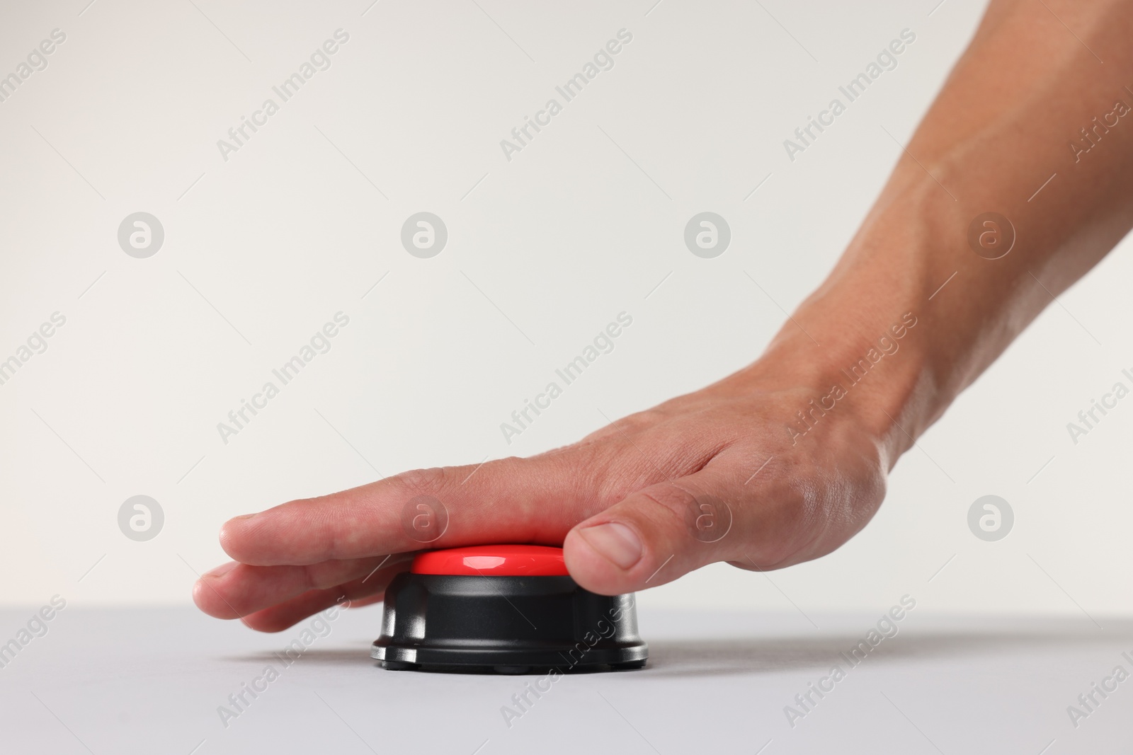 Man pressing red button on white background, closeup Photo of Man pressing red button on white background, closeup