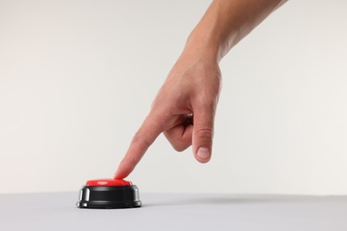 Photo of Man pressing red button on white background, closeup