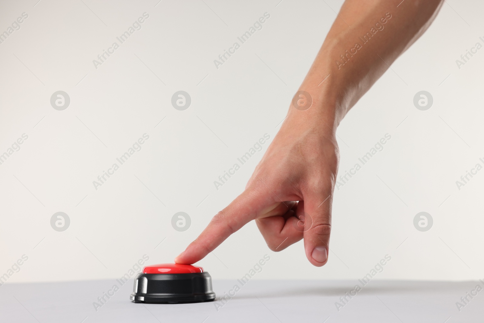 Man pressing red button on white background, closeup Photo of Man pressing red button on white background, closeup