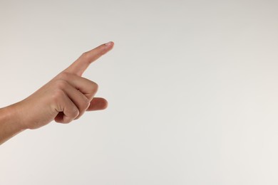 Photo of Man touching something on light grey background, closeup. Space for text