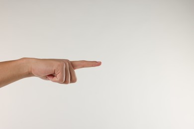 Photo of Man touching something on light grey background, closeup. Space for text