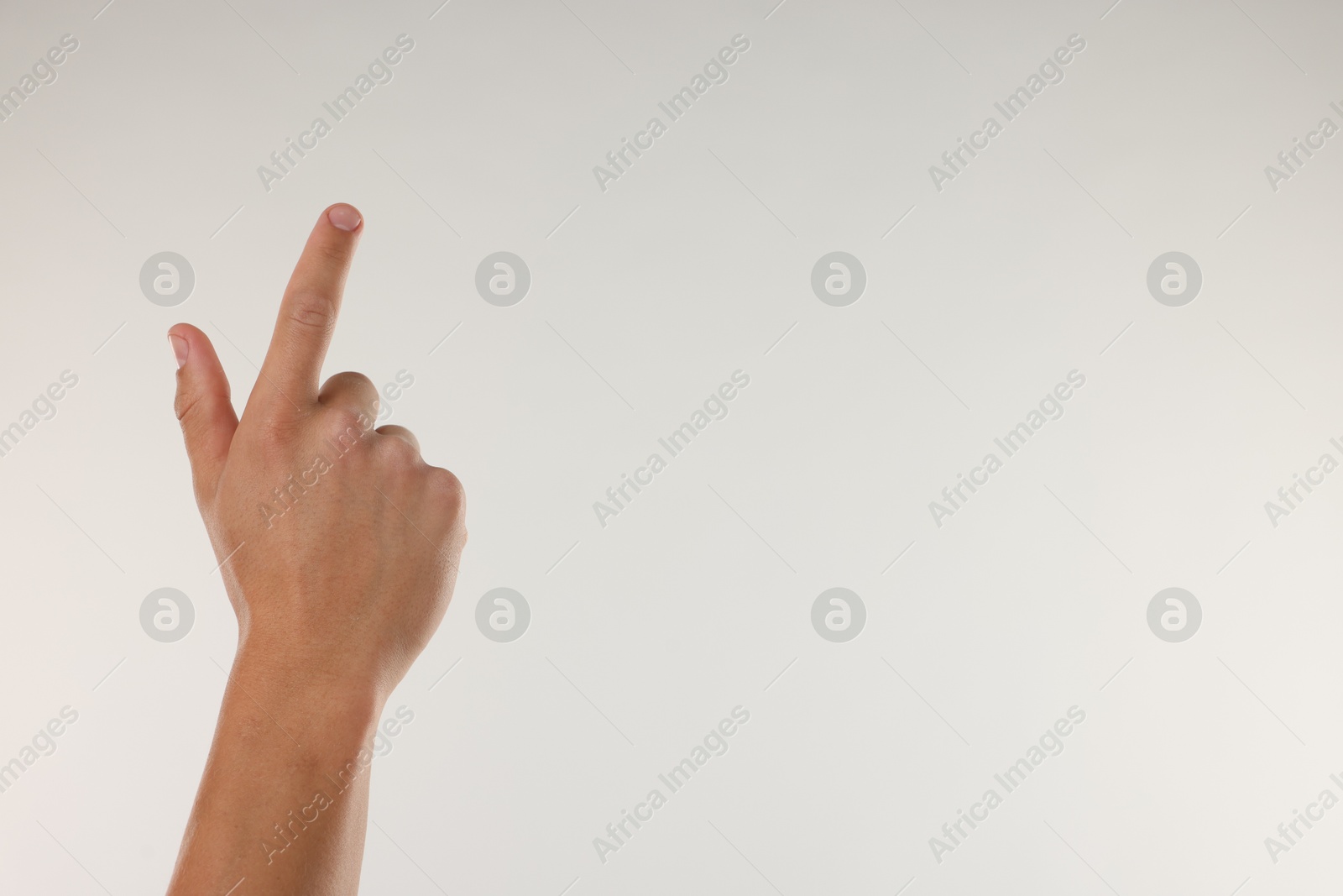 Photo of Man touching something on light grey background, closeup. Space for text