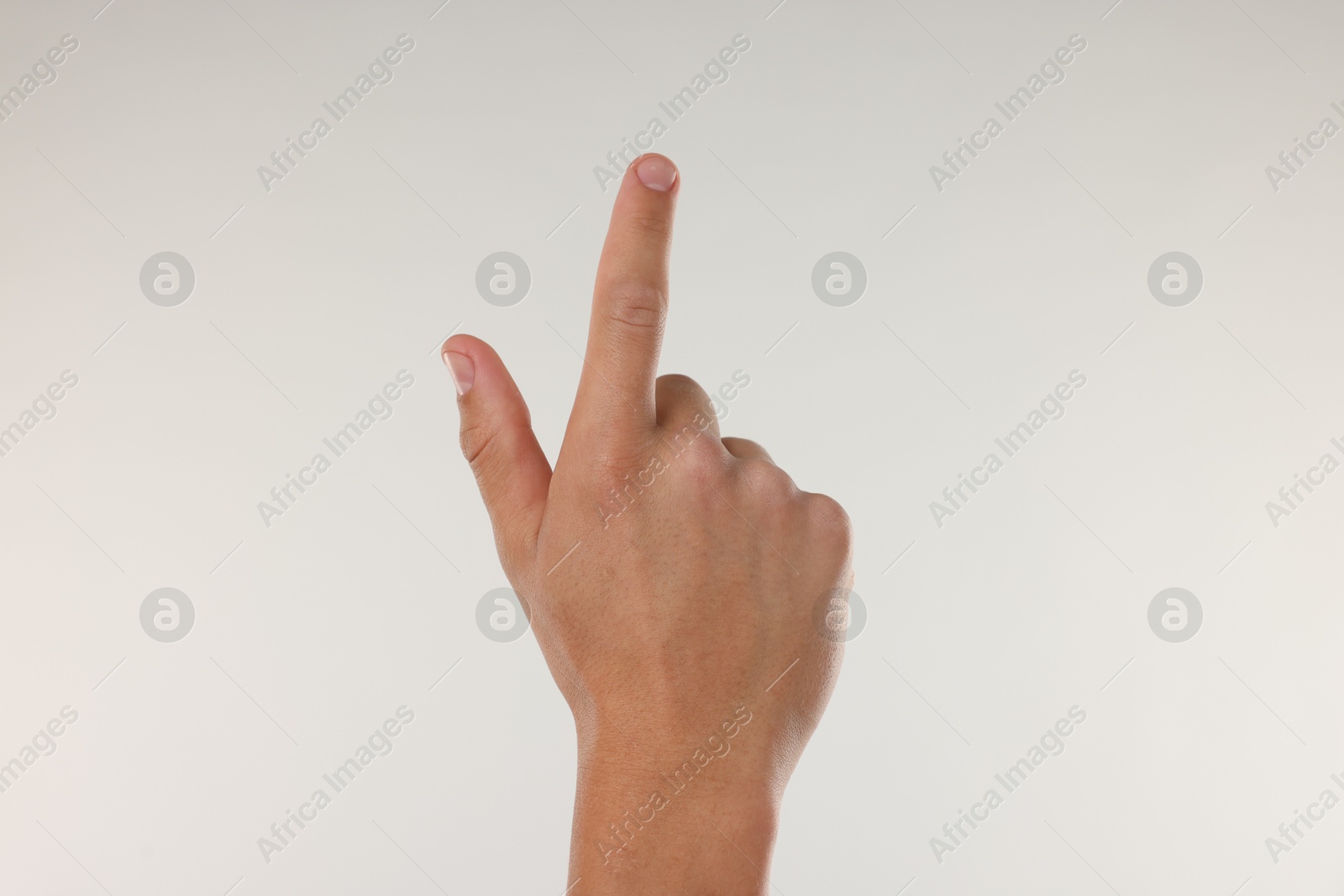 Photo of Man touching something on light grey background, closeup