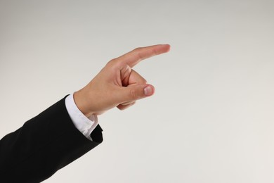 Photo of Man touching something on light grey background, closeup. Space for text