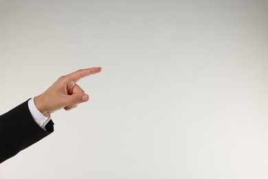 Photo of Man touching something on light grey background, closeup. Space for text