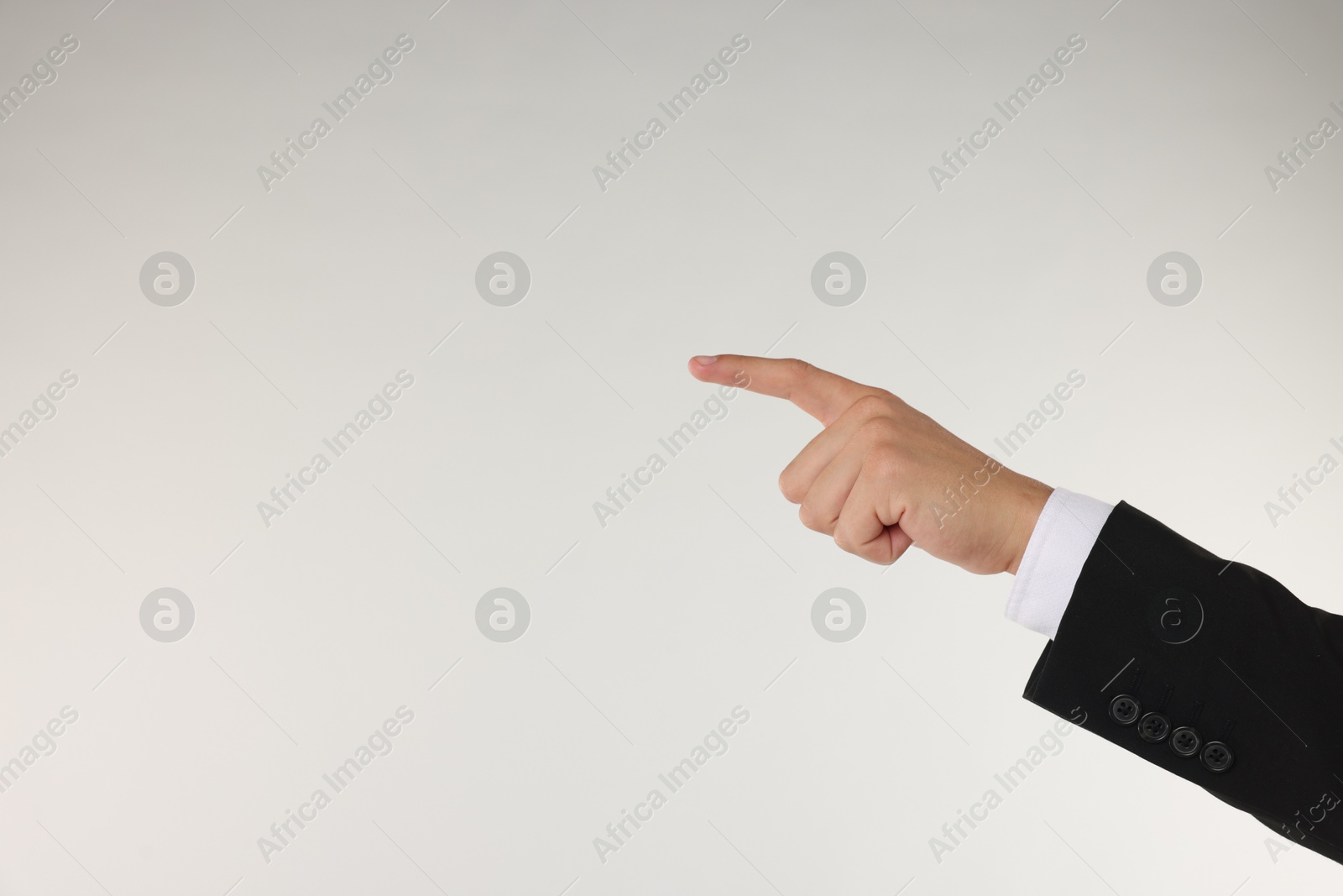 Man touching something on light grey background, closeup. Space for text Photo of Man touching something on light grey background, closeup. Space for text