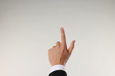 Photo of Man touching something on light grey background, closeup