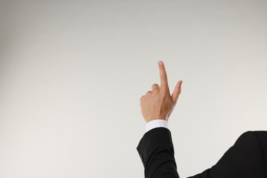 Photo of Man touching something on light grey background, closeup. Space for text